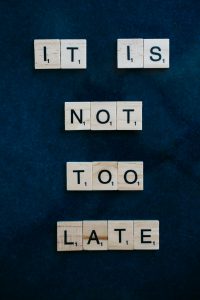 Scrabble-Steine bilden die Worte „It is not too late“ auf einem dunklen Hintergrund. Die Botschaft erinnert daran, dass es nie zu spät ist, Hilfe zu suchen – etwa bei ADHS und Reizüberflutung in der Schweiz.
