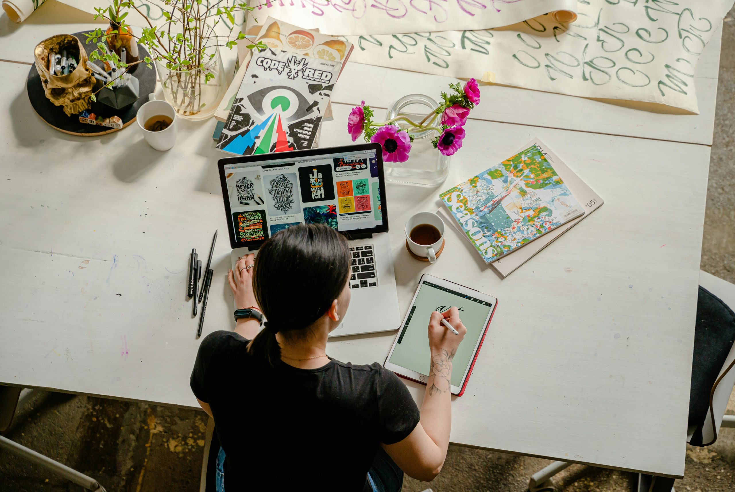 Eine kreative Berufstätige arbeitet gleichzeitig am Laptop und Tablet, um Designideen umzusetzen. Diese visuelle Darstellung zeigt, wie Menschen mit ADHS im Beruf in der Schweiz kreative Tätigkeiten strukturieren und effektiv nutzen können.