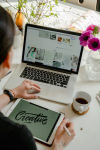Ein inspirierender Arbeitsplatz mit digitalen Geräten, kreativen Projekten und Blumenarrangement. Der Arbeitsplatz spiegelt wider, wie ADHS im Beruf in der Schweiz mit Gestaltungsspielraum und Selbstorganisation produktiv gestaltet werden kann.