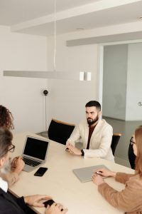 Ein Bewerber sitzt selbstbewusst einem Team gegenüber und beantwortet Fragen in einem modernen, hellen Büro. ADHS im Beruf in der Schweiz bedeutet nicht nur Herausforderungen, sondern auch individuelle Stärken, die im Bewerbungsprozess überzeugen können. Das Bild vermittelt Professionalität und Offenheit im Umgang mit Neurodiversität.