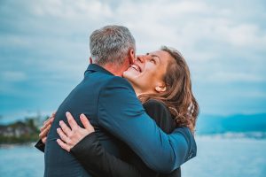 Eine herzliche Umarmung zwischen zwei Menschen am See vermittelt Lebensfreude und Nähe. Diese emotionale Stabilität kann helfen, die beruflichen Herausforderungen mit ADHS in der Schweiz besser zu meistern.