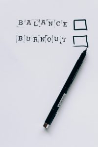 Ein Blatt Papier mit den Worten „Balance“ und „Burnout“, daneben Kästchen zum Ankreuzen und ein schwarzer Stift. Im Rahmen von ADHS Schweiz ist die Balance zwischen Belastung und Erholung ein zentrales Thema, um Burnout vorzubeugen. Die visuelle Darstellung regt zur Reflexion über den eigenen Zustand an.