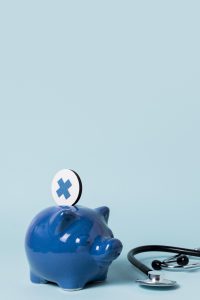 Ein blaues Sparschwein mit einem Gesundheits-Symbol und einem danebenliegenden Stethoskop steht auf hellem Hintergrund. Die Frage der Kostenübernahme ist bei ADHS Schweiz oft entscheidend – insbesondere, wenn es um Psychotherapie via Krankenkasse geht. Das Bild veranschaulicht die Verbindung zwischen Gesundheit und finanzieller Absicherung.