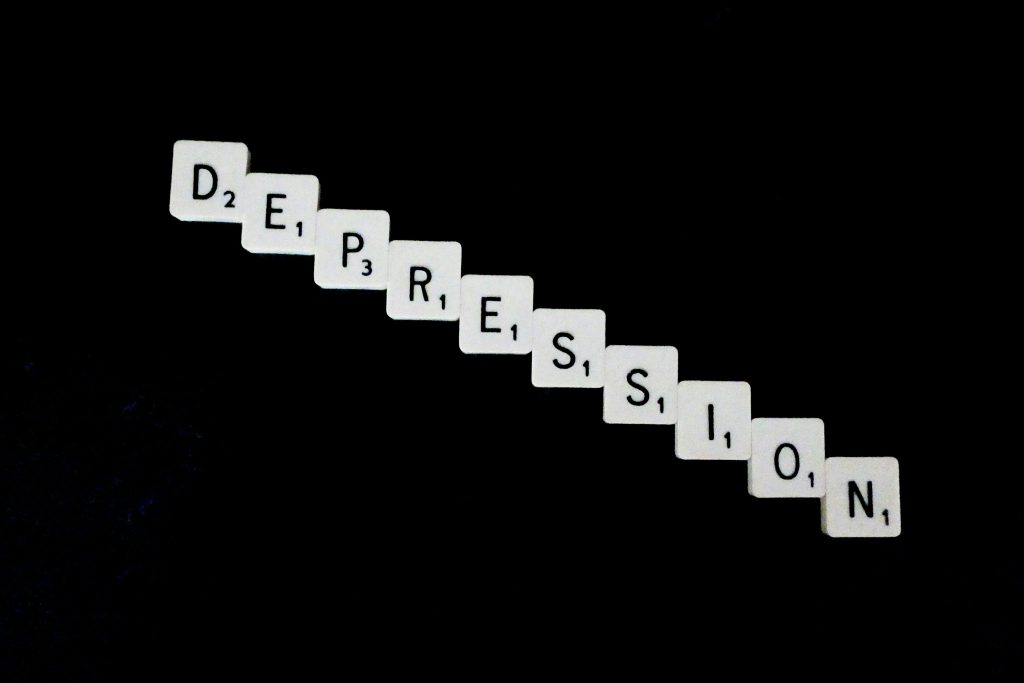 Scrabble-Buchstaben bilden das Wort „Depression“ auf schwarzem Hintergrund – symbolisches Bild für psychische Erkrankungen wie Depression, die häufig mit ADHS einhergehen können.
