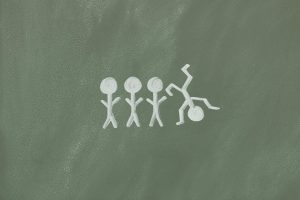 Vier Strichmännchen in einer Reihe – eines davon steht auf dem Kopf – als Metapher für neurodiverse Denkweisen bei ADHS und Autismus, die sich oft von der Norm abheben.