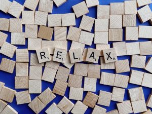 Das Wort „RELAX“ liegt auf unzähligen Holzplättchen – ein Symbol für den Wunsch nach Ordnung im Chaos. Bei ADHS ist Reizüberflutung in der Schweiz oft Teil des Alltags, und gezielte Entspannungstechniken können helfen, Stress abzubauen. Eine kleine Erinnerung daran, sich Pausen zu gönnen.