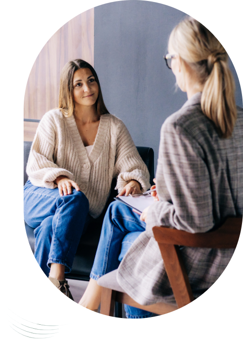 Psychotherapiesitzung bei klaroADHS: Die Patientin sitzt auf einem Sofa, die Therapeutin auf einem Stuhl schräg gegenüber