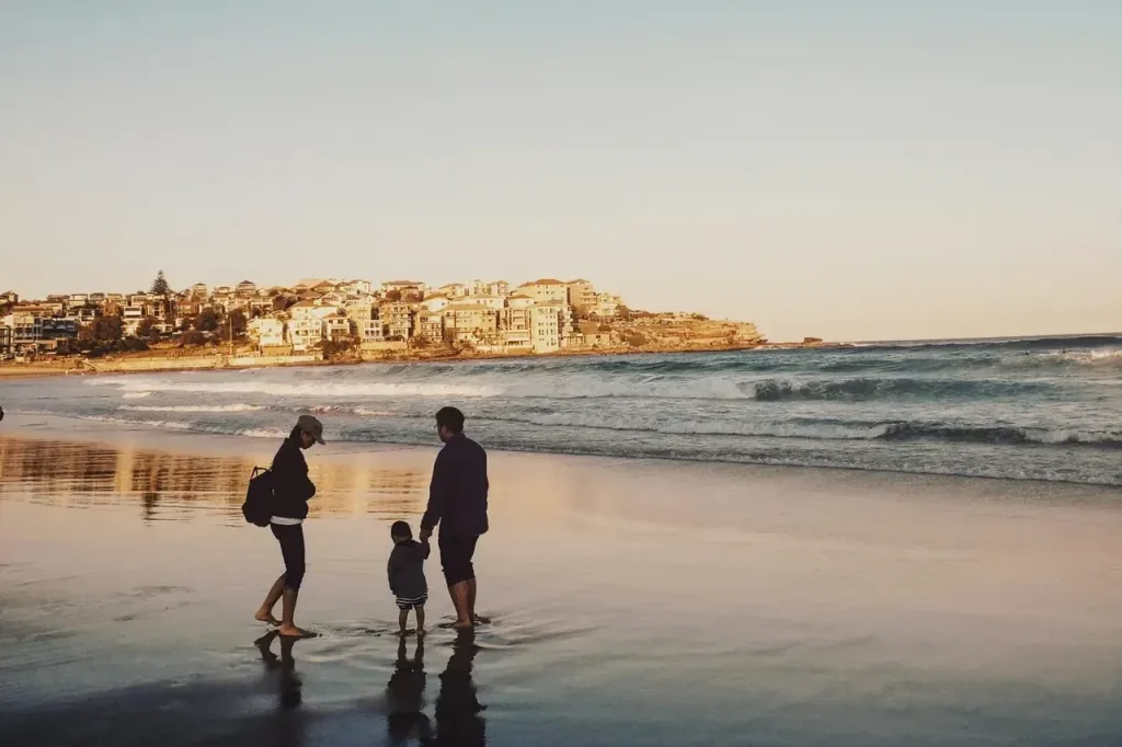 Familie geht bei Sonnenuntergang am Strand spazieren
