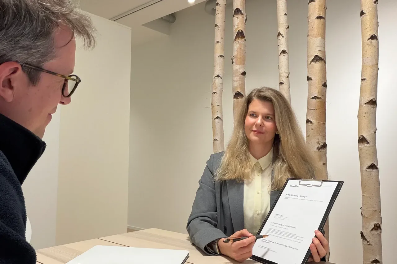 Therapeutin der klaro ADHS Praxis mit Klemmbrett im Erstgespräch mit einem Patienten