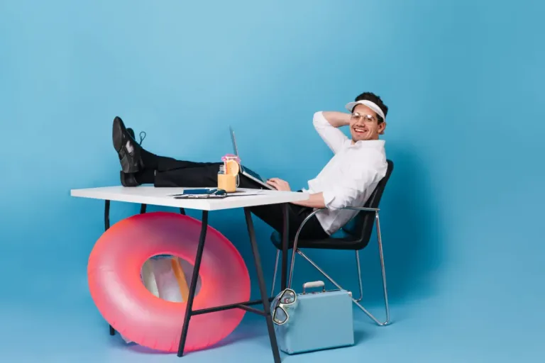 Ein Mann in Businesskleidung sitzt lässig mit Sonnenvisier und Cocktail am Schreibtisch, ein Schwimmring lehnt am Tisch. Work-Life-Balance ist auch bei ADHS Schweiz ein wichtiges Thema, um Überforderung zu vermeiden. Das Bild vermittelt auf humorvolle Weise die Notwendigkeit von Leichtigkeit im Alltag.