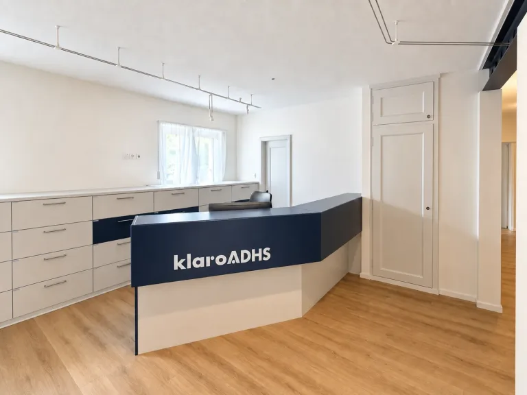 Heller Empfangsbereich der klaro ADHS Praxis in Biel mit Empfangstresen und Logo