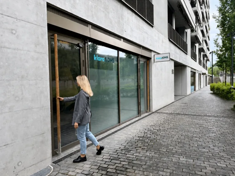 Eine Frau betritt den Eingang der klaro ADHS Praxis im Greencity Quartier in Zürich