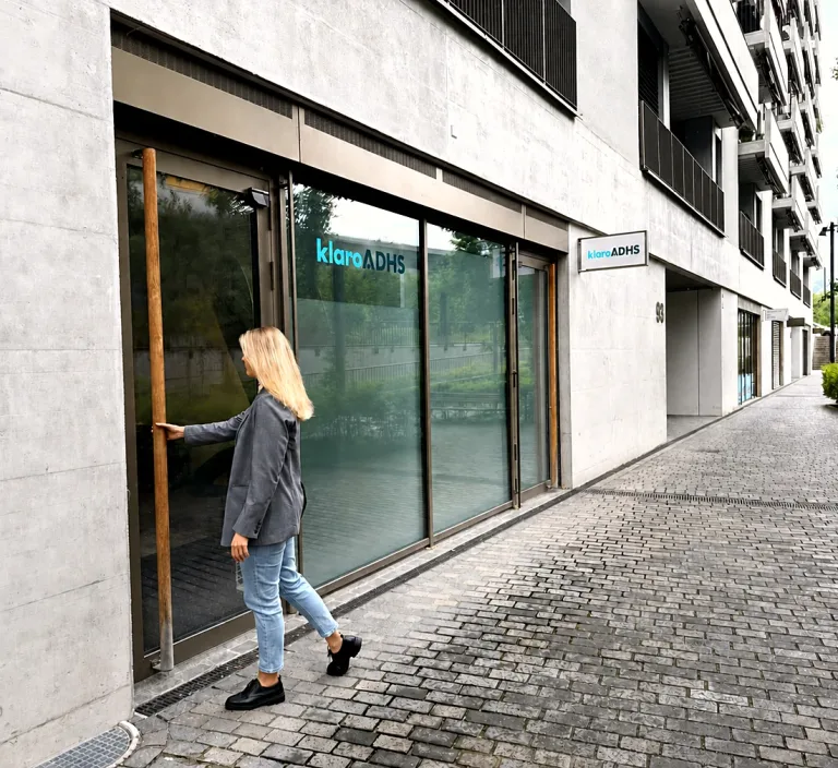 Besucherin öffnet die Tür zur klaro ADHS Praxis in Zürich Greencity, Maneggstrasse 93