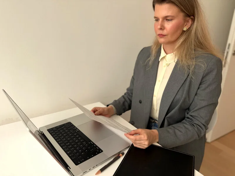 Fachärztin von klaro-ADHS prüft Anmeldeunterlagen am Laptop in der Praxis im Greencity Zürich
